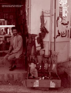 A Yemeni man sells AK-47 assault rifles outside his shop... village in the Haraz Mountains, 2004. © Christian Gahre